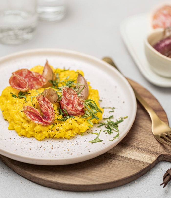 Salami nach Mailänder Art mit Risotto Milanese und Schalotten